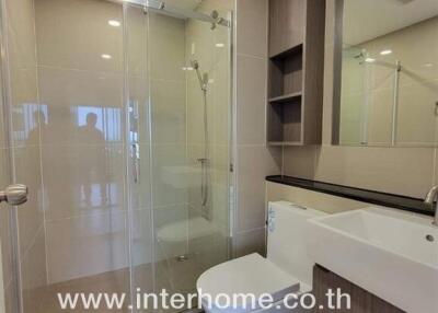 Modern bathroom with glass shower and wooden cabinets