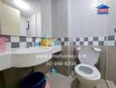 Modern bathroom with wall-mounted sink, toilet, and tiled walls