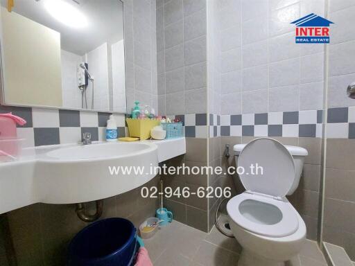 Modern bathroom with wall-mounted sink, toilet, and tiled walls