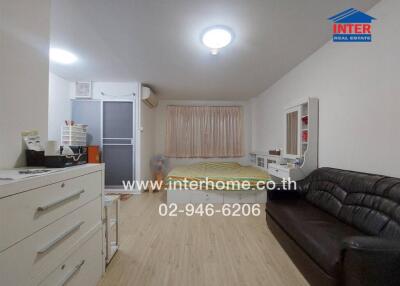 Spacious modern bedroom with double bed, wardrobe, and leather sofa