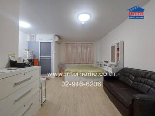 Spacious modern bedroom with double bed, wardrobe, and leather sofa