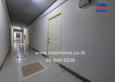 Well-lit corridor in a building with multiple doors and tiled flooring