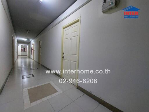 Well-lit corridor in a building with multiple doors and tiled flooring