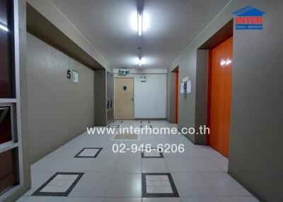 Interior view of a clean and well-lit apartment building hallway with numbered doors