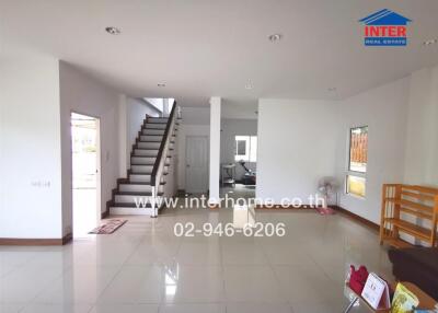 Spacious living room with staircase and modern floor tiling