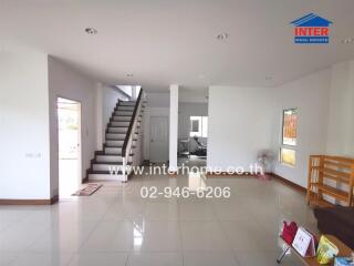 Spacious living room with staircase and modern floor tiling