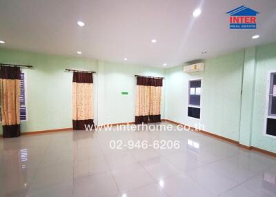 Spacious and brightly lit living room with polished floor tiles and large windows