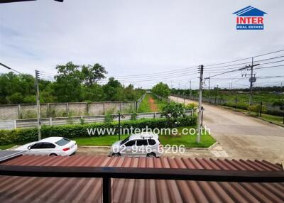 Spacious external view from property showcasing green landscape and open road