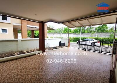 Spacious covered patio area with modern tiled flooring and scenic view