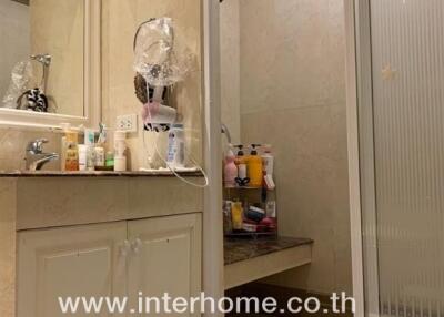 Spacious bathroom with shower and ample storage space featuring mirrored cabinets and personal care products