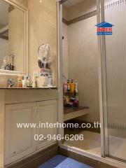 Spacious bathroom with shower and ample storage space featuring mirrored cabinets and personal care products