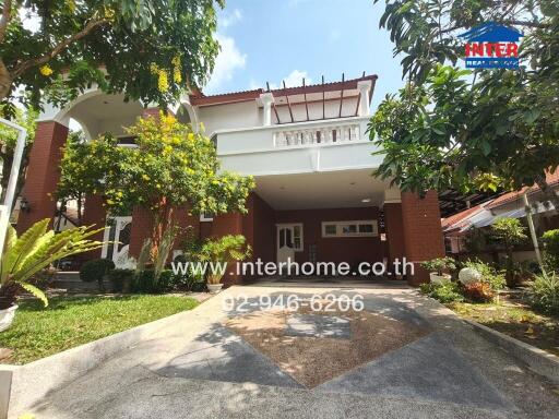 Front view of a modern two-story house with lush greenery