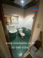 Compact bathroom with green tiles and modern fixtures