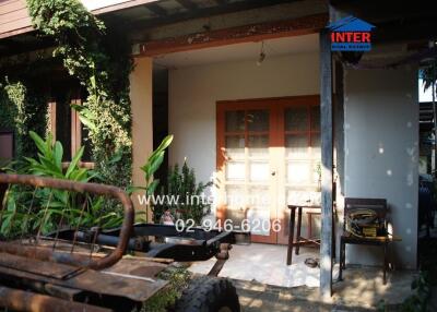 Cozy exterior view of a house with a rustic wooden door and lush green plants