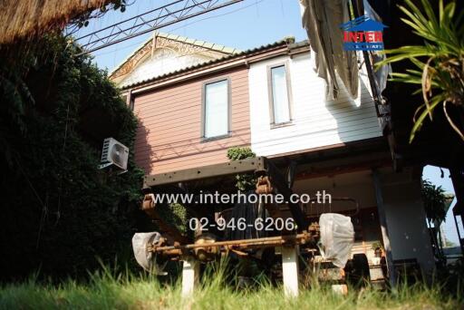 Exterior view of a small residential building with lush garden