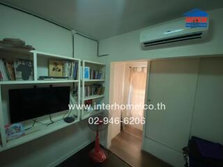 Modern living room with built-in shelving and air conditioning unit