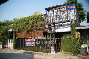 Exterior view of a rustic building with abundant green ivy