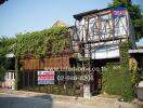 Exterior view of a rustic building with abundant green ivy