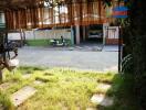 Spacious outdoor parking area with greenery and partial shade