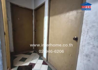 Interior view of a hallway with two doors and tiled flooring