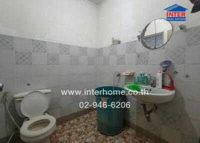 Spacious bathroom with tiled walls and basic amenities