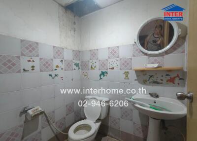 Small bathroom with tiled walls and basic fixtures