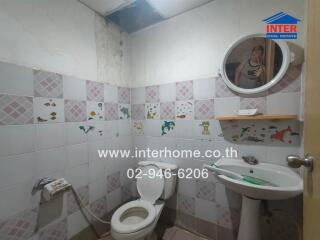 Small bathroom with tiled walls and basic fixtures