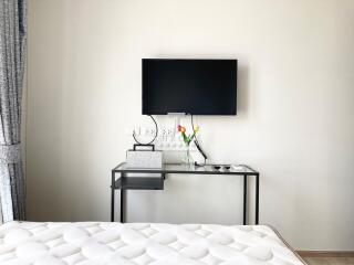 Modern bedroom with wall-mounted television and minimalist design