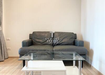 Modern living room with a comfortable grey sofa and a glass coffee table