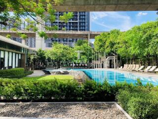 Refreshing outdoor pool surrounded by lush greenery in a modern residential apartment complex