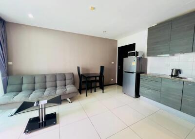 Spacious open-plan living area with kitchen, featuring modern furniture and appliances