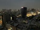 Nighttime cityscape view from high-rise building, showcasing urban skyline with illuminated buildings