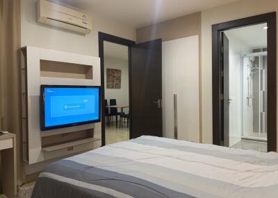 Modern bedroom with connected bathroom and entertainment unit