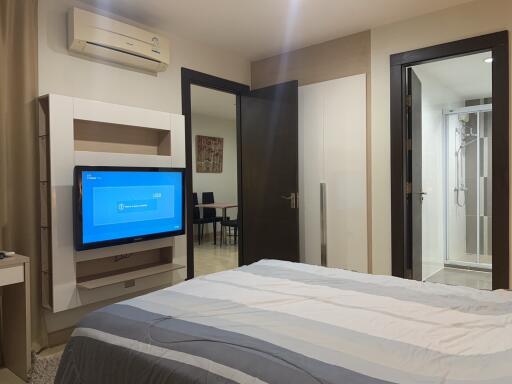 Modern bedroom with connected bathroom and entertainment unit