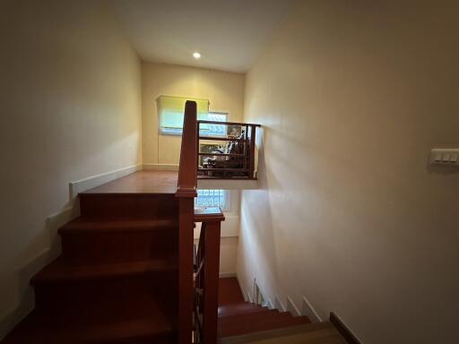 Interior view of a wooden staircase leading to an upper level with warm lighting