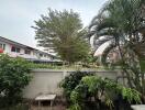 Lush green outdoor area with residential buildings in the background