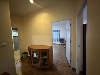 Spacious corridor leading to rooms with hardwood floors and natural lighting