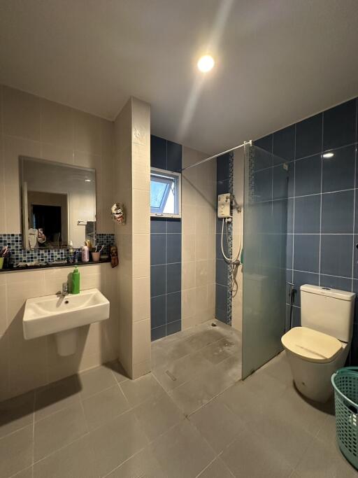 Compact modern bathroom with shower, toilet and sink