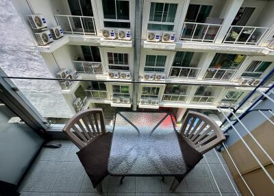 Compact balcony with seating and a view of the building facade
