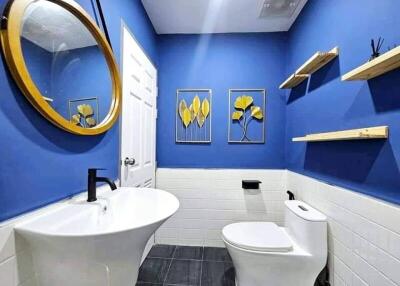 Modern bathroom with bright blue walls and gold accents