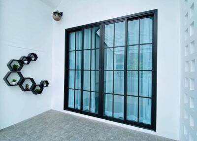 Modern entryway with large black framed glass doors and decorative wall planters