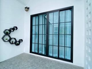 Modern entryway with large black framed glass doors and decorative wall planters