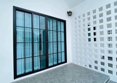 Modern balcony with large sliding glass doors and decorative wall
