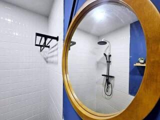 Modern bathroom with white and blue tiles and a circular mirror