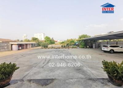 Spacious paved driveway with parking and greenery in residential property