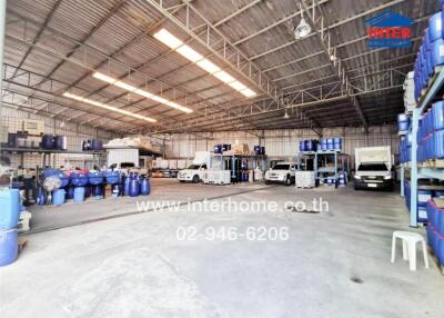 Spacious industrial warehouse interior with vehicles and storage items