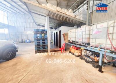 Spacious industrial building interior with storage and vehicles