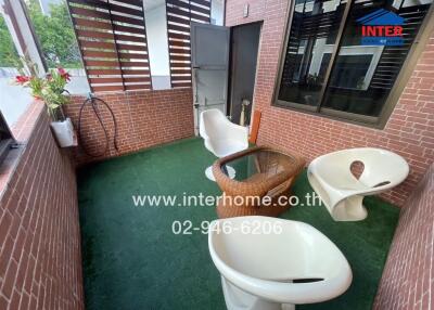 Modern outdoor patio with synthetic grass and stylish seating area
