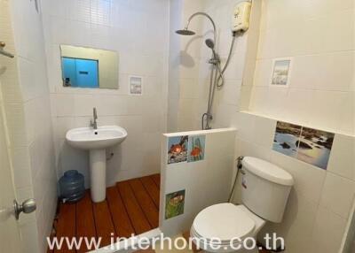 Compact bathroom with white fixtures and tiled walls in a city apartment