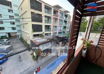 View from balcony showing surrounding buildings and street